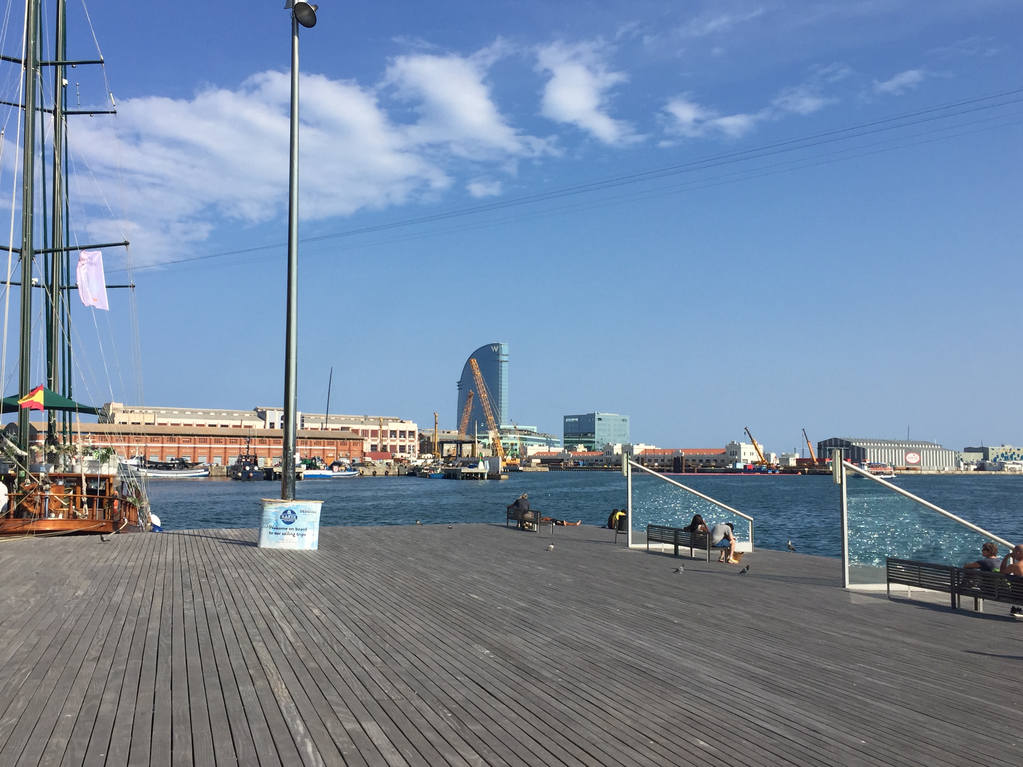 A scenic view off the pier at Maremagnum. The old meets the new both in boats and buildings, as we see the warehouses on Barceloneta, as well as the notable shape of the W Hotel at the tip of San Sebastian Beach.