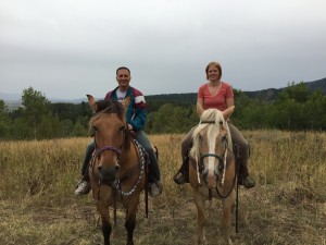 Mark and Lizzy smiling amidst the fresh air while horseback riding with the Rockin' M Ranch in Alpine, WY.