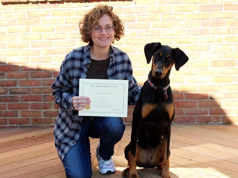 Dog Owner Holding Canine Good Citizen Certificate With Dog